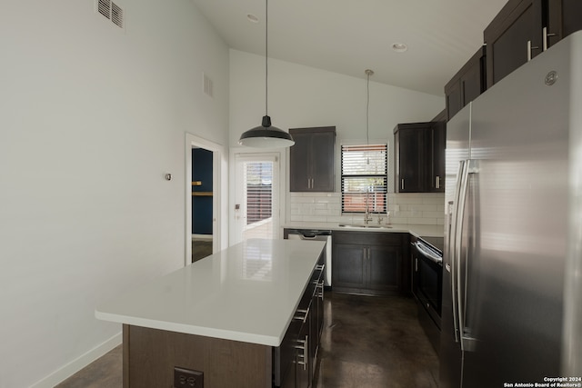 kitchen featuring backsplash, dark brown cabinets, stainless steel appliances, decorative light fixtures, and a center island