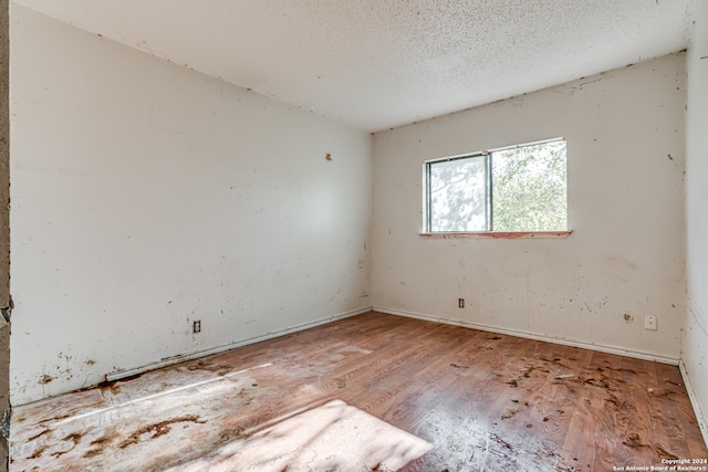 unfurnished room featuring a textured ceiling and hardwood / wood-style flooring