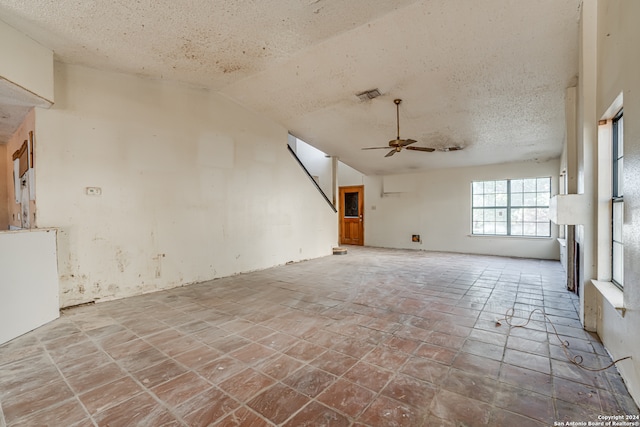 unfurnished living room featuring a textured ceiling, ceiling fan, and lofted ceiling