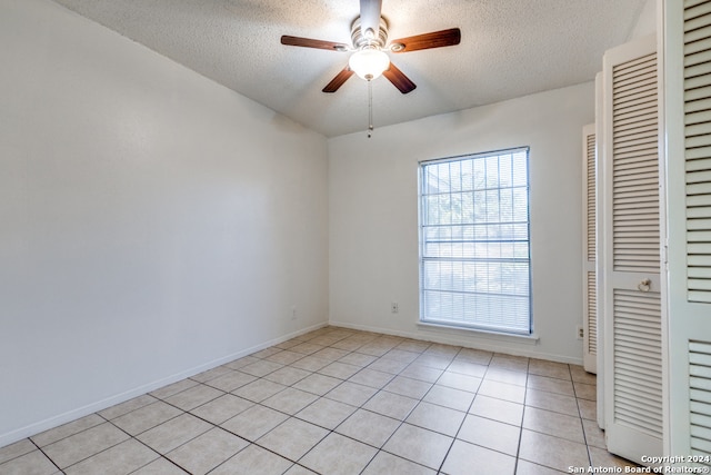 unfurnished bedroom with ceiling fan, light tile patterned floors, and a textured ceiling