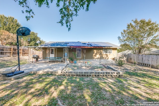 back of property featuring solar panels, a yard, and a patio area