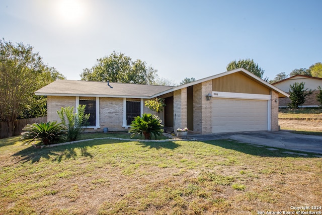 single story home with a garage and a front lawn