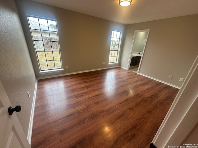 spare room featuring plenty of natural light and dark hardwood / wood-style floors