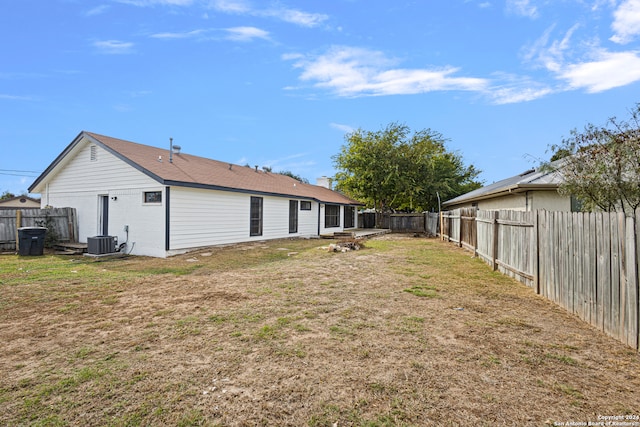 back of property with cooling unit and a lawn