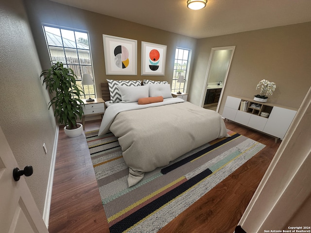 bedroom with ensuite bath and dark wood-type flooring