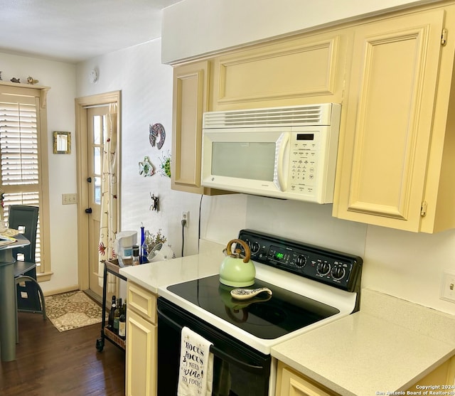 kitchen featuring cream cabinets, dark hardwood / wood-style flooring, and black electric range oven