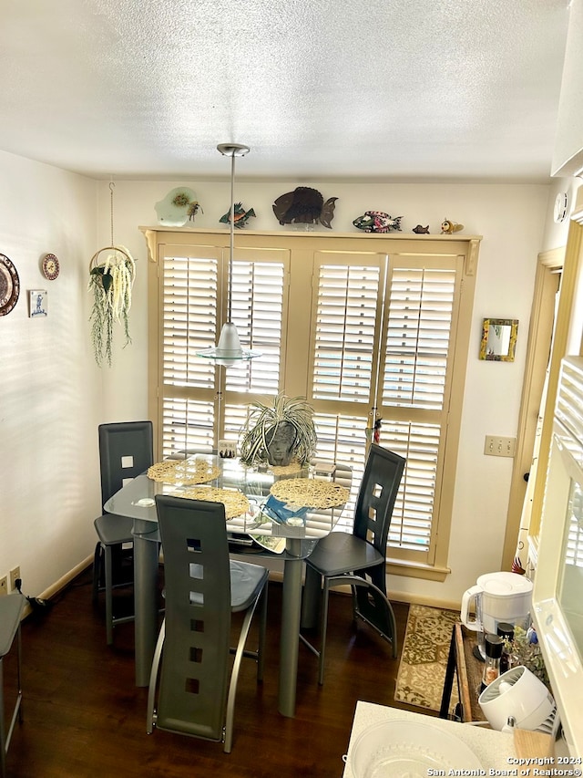 dining area featuring dark hardwood / wood-style floors and a textured ceiling