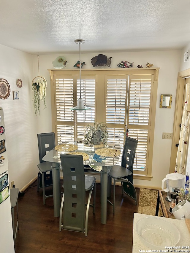 dining room featuring dark hardwood / wood-style flooring and a textured ceiling