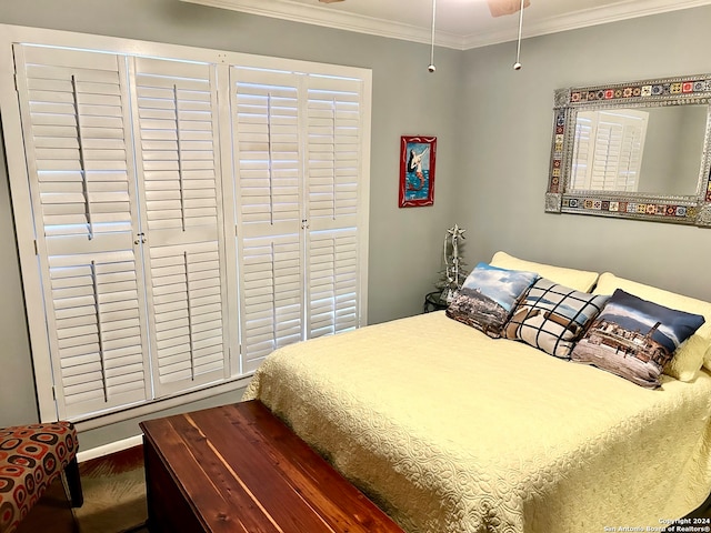 bedroom featuring dark hardwood / wood-style floors, ceiling fan, and crown molding