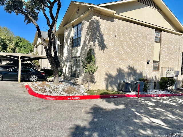 view of property exterior featuring central AC and a carport