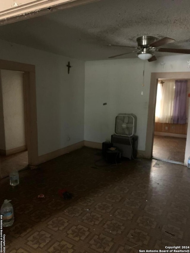 interior space with ceiling fan and a textured ceiling