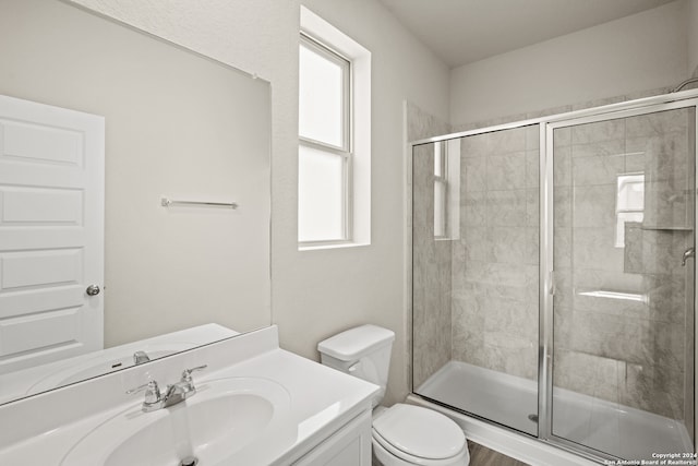 bathroom with an enclosed shower, vanity, and toilet