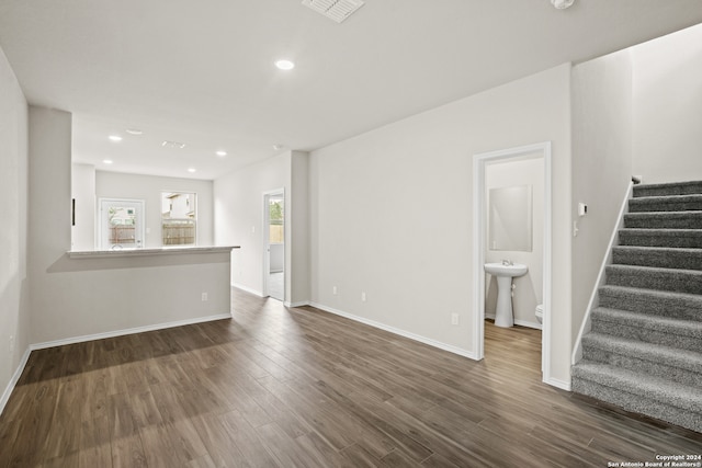 unfurnished living room featuring dark hardwood / wood-style flooring and sink