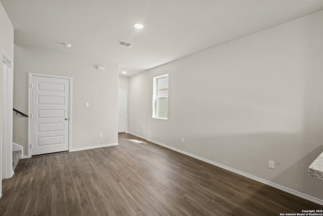 unfurnished room with dark wood-type flooring