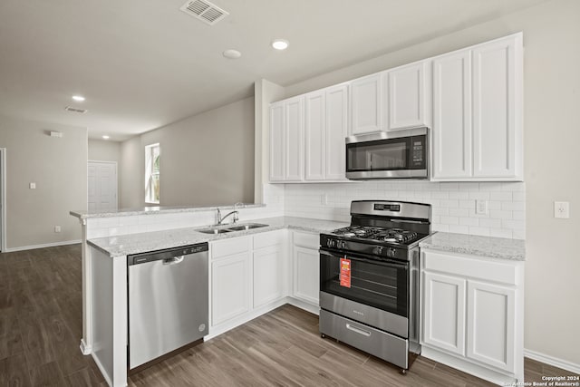 kitchen featuring dark hardwood / wood-style flooring, white cabinetry, and appliances with stainless steel finishes