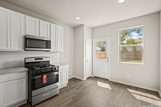 kitchen with white cabinets, appliances with stainless steel finishes, and dark wood-type flooring