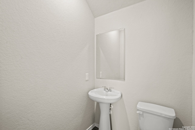 bathroom featuring toilet and vaulted ceiling