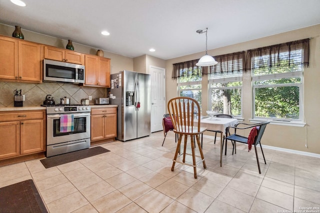 kitchen with decorative light fixtures, light tile patterned floors, stainless steel appliances, and tasteful backsplash