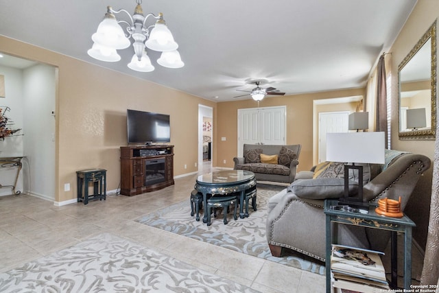 tiled living room featuring ceiling fan with notable chandelier