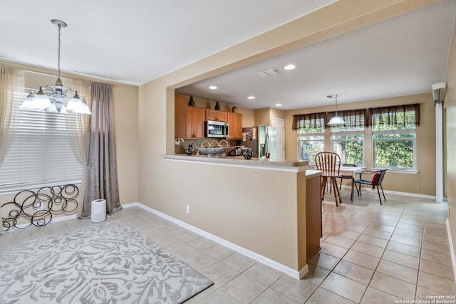 kitchen with pendant lighting, backsplash, light tile patterned flooring, stainless steel appliances, and a chandelier