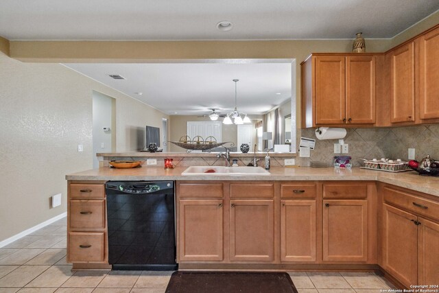 kitchen with tasteful backsplash, sink, light tile patterned floors, decorative light fixtures, and black dishwasher