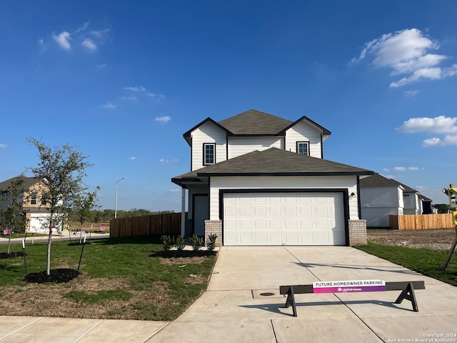 view of front of property featuring a front yard and a garage