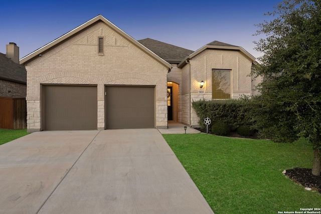 view of front of house with a garage and a lawn