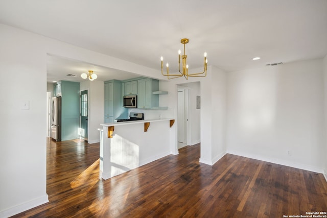 kitchen with green cabinets, an inviting chandelier, stainless steel appliances, a kitchen bar, and dark hardwood / wood-style flooring