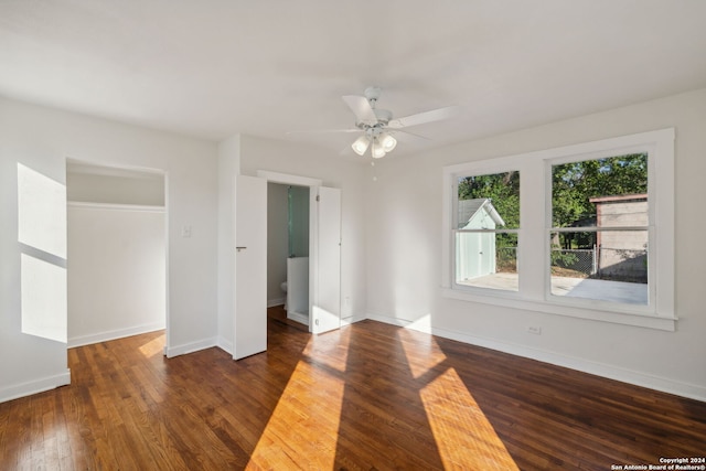 empty room with ceiling fan and dark hardwood / wood-style flooring