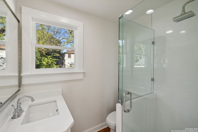 bathroom featuring vanity, toilet, and walk in shower