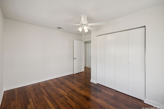 unfurnished bedroom featuring ceiling fan, dark hardwood / wood-style flooring, and a closet