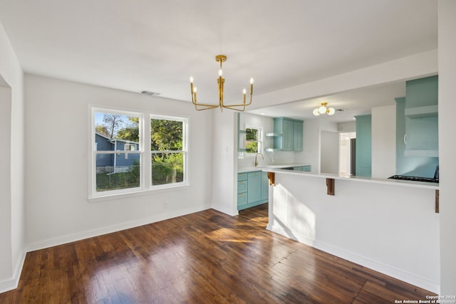 interior space with dark hardwood / wood-style floors, a kitchen bar, hanging light fixtures, green cabinets, and kitchen peninsula