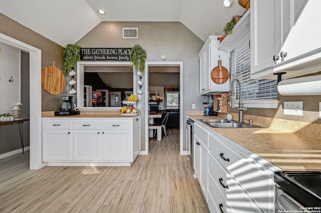 kitchen with light hardwood / wood-style flooring, white cabinetry, lofted ceiling, and sink