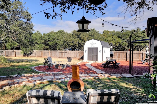 view of yard featuring a storage shed and an outdoor fire pit