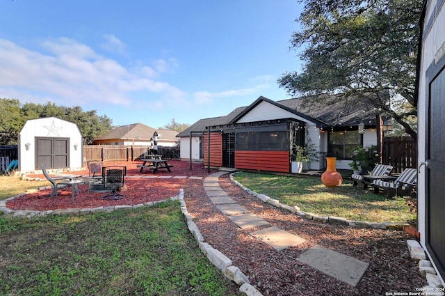 view of yard featuring a storage unit and an outdoor fire pit