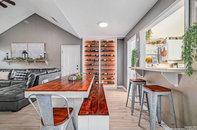 dining area featuring vaulted ceiling and light wood-type flooring