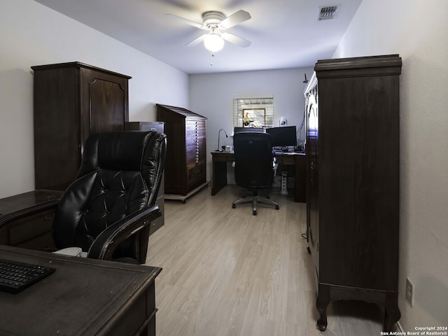 home office with light wood-type flooring and ceiling fan