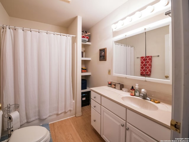 full bathroom with hardwood / wood-style floors, vanity, toilet, and shower / bath combo with shower curtain