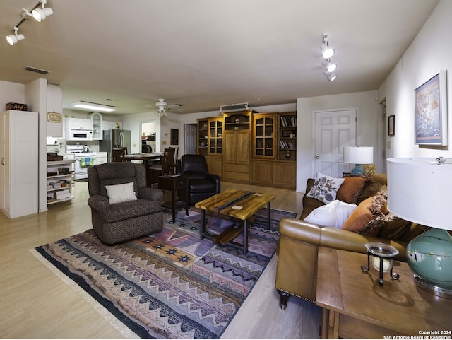 living room with hardwood / wood-style floors, ceiling fan, and rail lighting