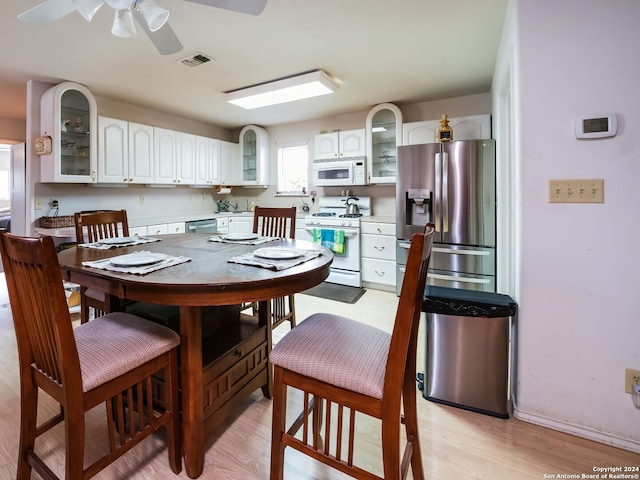 kitchen with white cabinets, ceiling fan, stainless steel appliances, and light hardwood / wood-style flooring