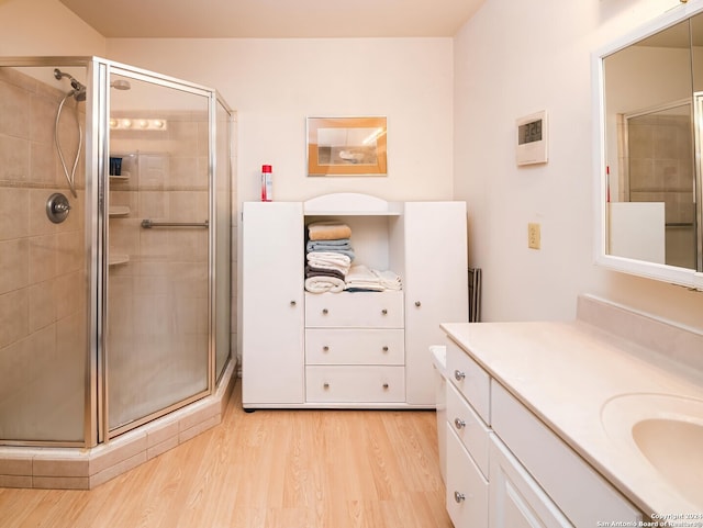 bathroom featuring hardwood / wood-style floors, vanity, and an enclosed shower