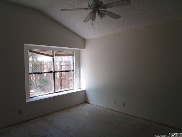 unfurnished room with lofted ceiling, ceiling fan, and a textured ceiling