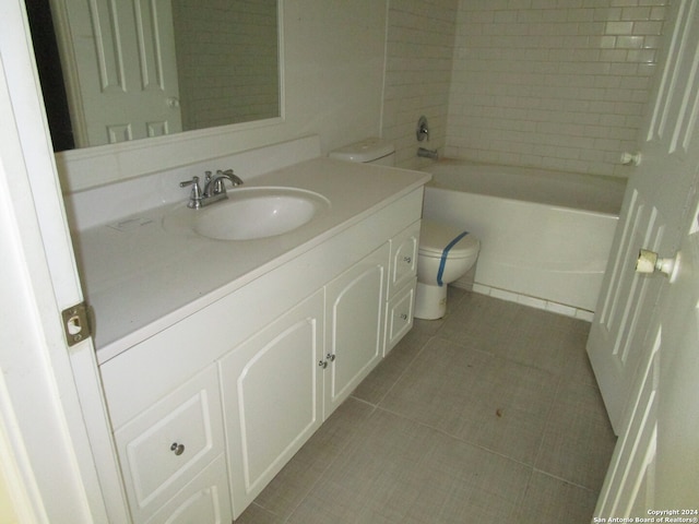 full bathroom with tiled shower / bath, tile patterned flooring, vanity, and toilet