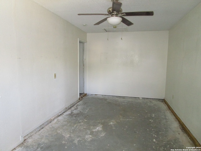 spare room with ceiling fan, a textured ceiling, and concrete floors