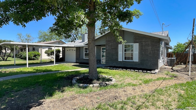 view of front of property featuring a front yard, a garage, and a carport