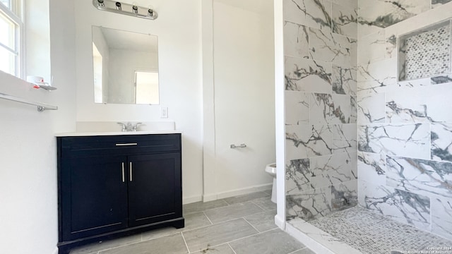 bathroom featuring tiled shower, vanity, and toilet