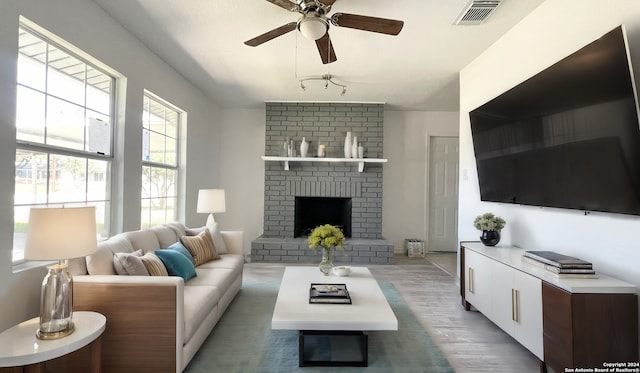 living room featuring a brick fireplace, ceiling fan, and hardwood / wood-style flooring