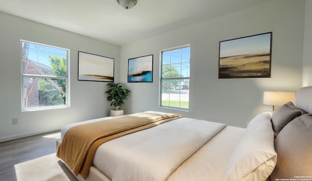 bedroom with hardwood / wood-style flooring and multiple windows