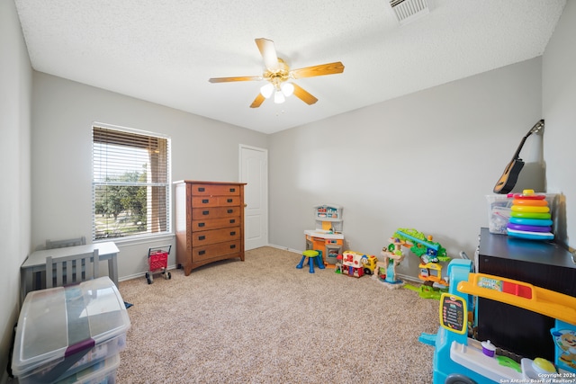 rec room with carpet flooring, ceiling fan, and a textured ceiling