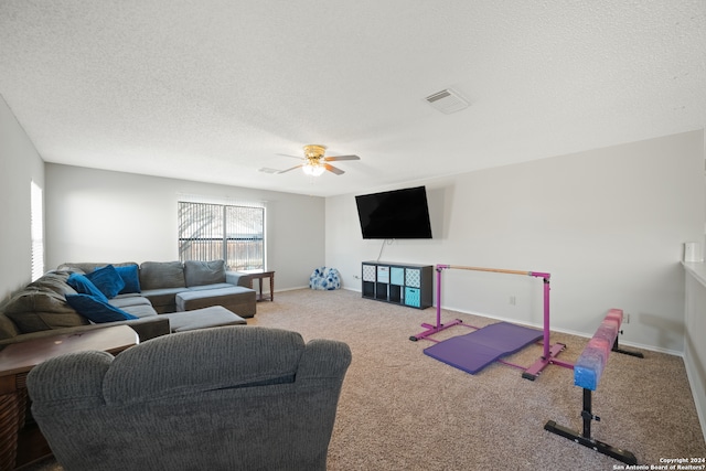 living room with a textured ceiling, carpet floors, and ceiling fan